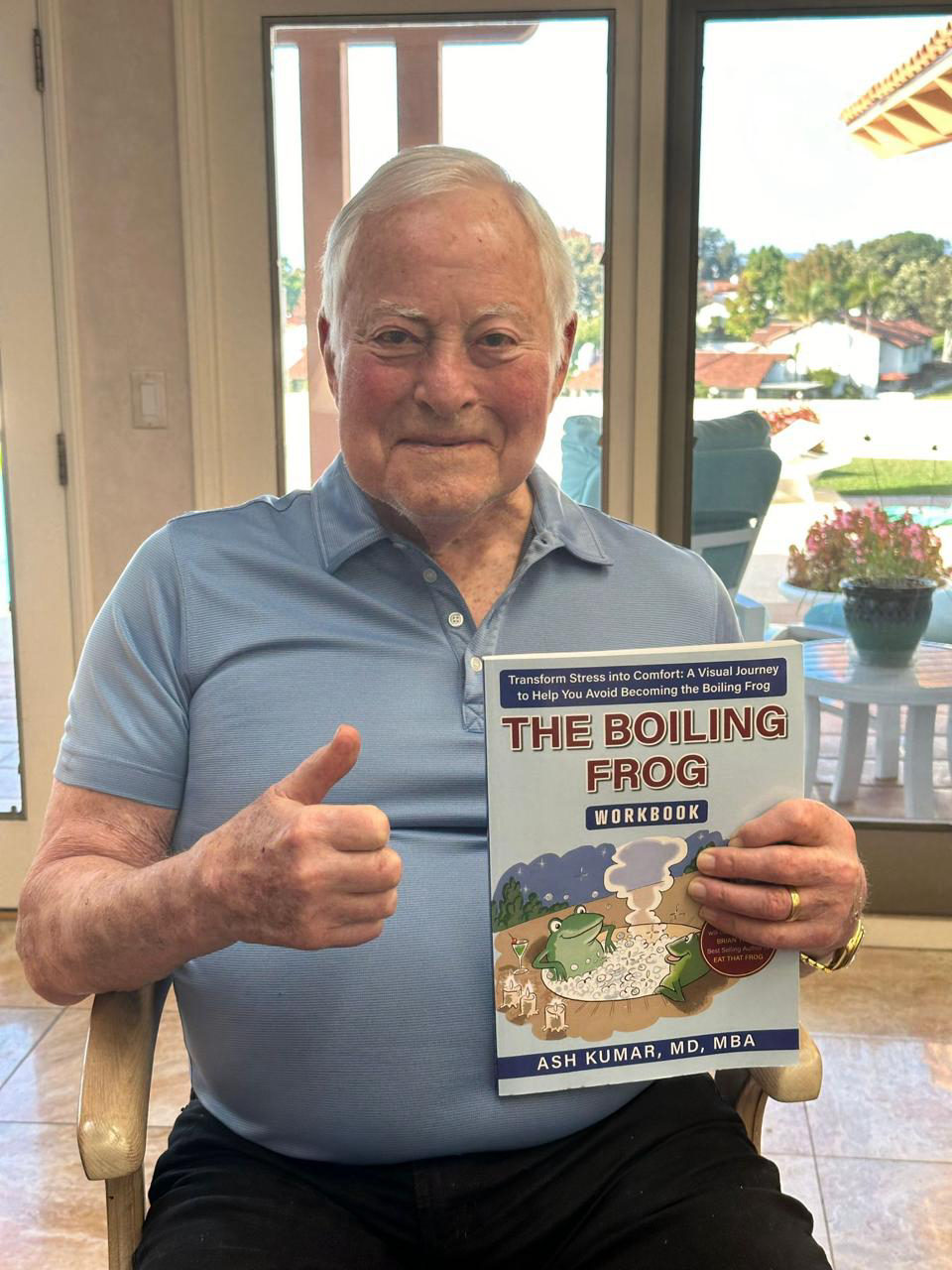 Brian Tracy holding The Boiling Frog companion workbook