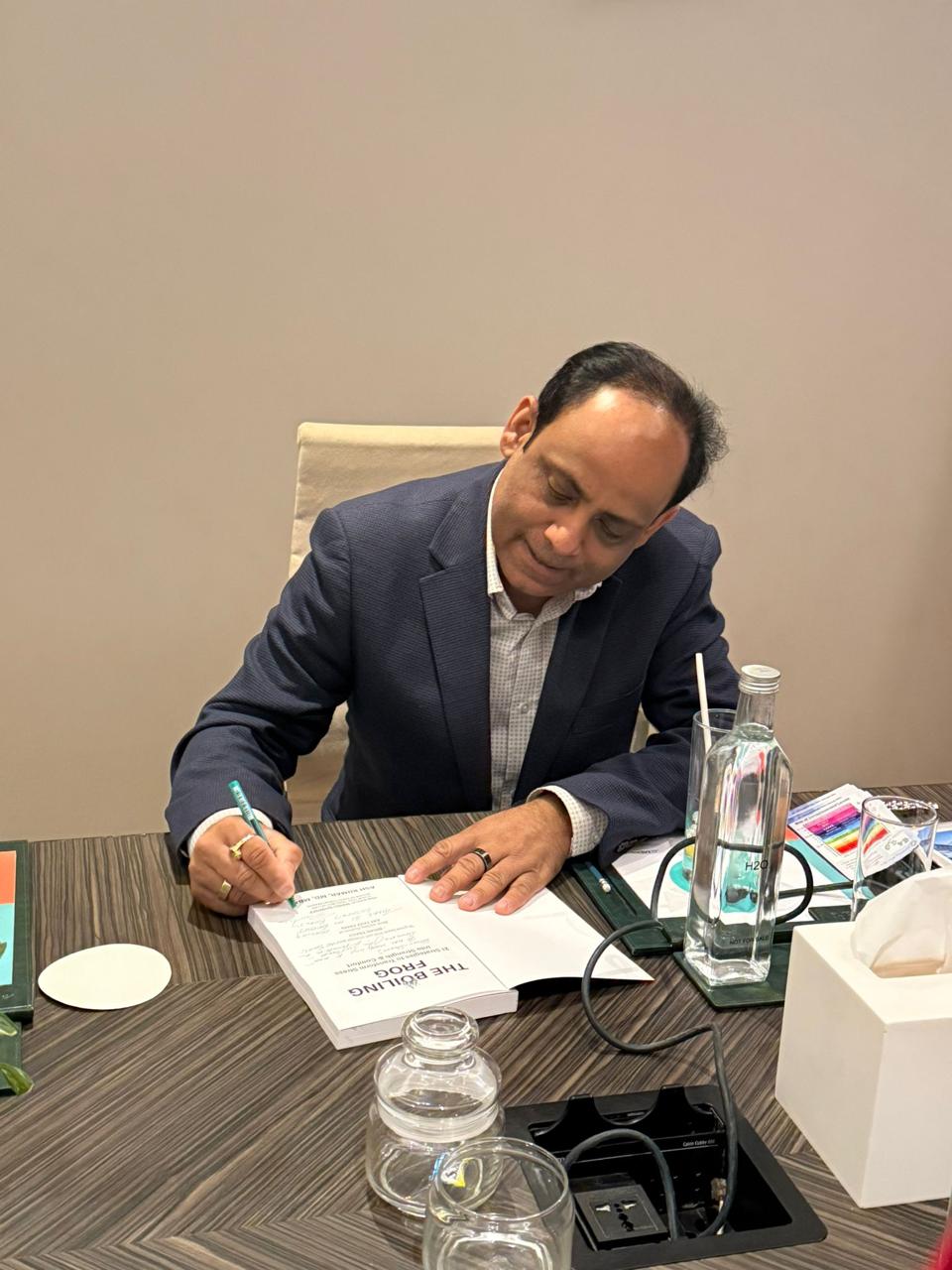 Dr Ash Kumar signing copies of The Boiling Frog at the book launch